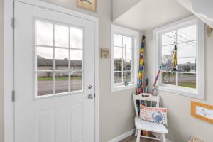 a white door in a room with windows at Coho Cottage in Rockaway Beach +7 photos