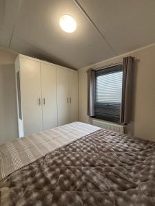 a bedroom with a large bed and a window at Noa aan Zee in Westerland