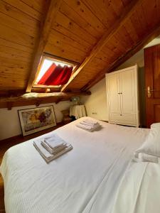 a bedroom with a white bed with a wooden ceiling at A casa dei CHICCHI in Settecamini