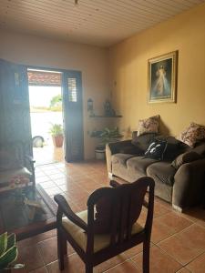 a living room with a couch and a chair at Casa Tradição do Catu in Aquiraz