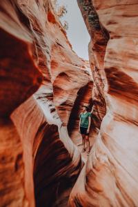 a man is walking through a slot canyon at Bryce Canyon Escalante Glamping in Cannonville +7 photos