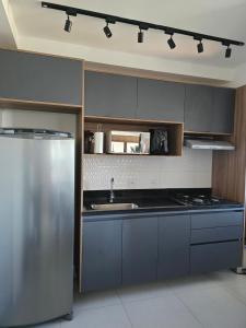 a kitchen with a sink and a stainless steel refrigerator at Emilie Home in Sao Jose do Rio Preto