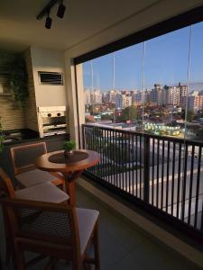 a balcony with a table and a view of a city at Emilie Home in Sao Jose do Rio Preto