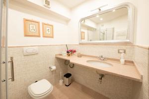 a bathroom with a sink and a toilet and a mirror at Egea Beach House in Lido di Camaiore +26 photos