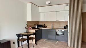 a kitchen with white cabinets and a table and chairs at Casa Nostra in Białystok