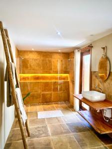 a bathroom with a shower and a sink at Chalé Caju Knots in Parajuru
