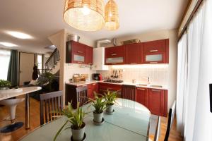 a kitchen with red cabinets and a glass table with plants at Egea Beach House in Lido di Camaiore