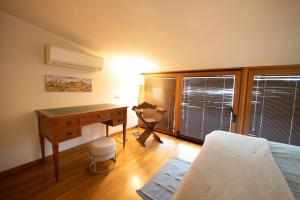 a bedroom with a desk and a bed and a window at Egea Beach House in Lido di Camaiore