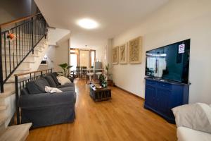 a living room with a couch and a flat screen tv at Egea Beach House in Lido di Camaiore