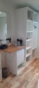 a kitchen with white cabinets and a wooden counter at Surf Shack 3 - Zimmer am Strand, Parkplatz, WLAN, Kiten, Surfen, Chillen im Gemeinschaftsgarten, Naturstrand, Restaurants und Geschäfte in 5 Minuten erreichbar, lockere Atmosphäre in Dahme +11 photos