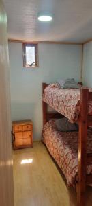 a bedroom with two bunk beds and a night stand at Cabaña Vicente del Mar in Isla Negra