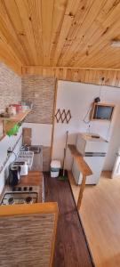a kitchen with a stove and a wooden ceiling at Cabaña Vicente del Mar in Isla Negra