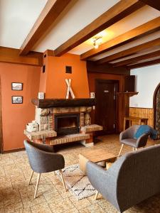 a living room with a fireplace and chairs at Auberge La Cléa in La Pesse