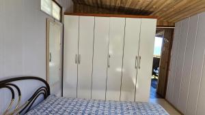 a bedroom with a bed and a white cabinet at Casa ceu in Florianópolis