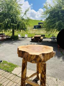 a wooden table in a park with a picnic table at Auberge La Cléa in La Pesse +4 photos