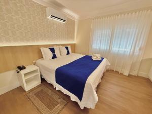 a bedroom with a large bed and a window at CAPÃO Da CANOA MAR HOTEL in Capão da Canoa