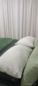 a bed with white pillows on top of it at Bushman Kraal Lux in Soweto