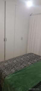 a bed with a green blanket on top of it at Bushman Kraal Lux in Soweto +2 photos