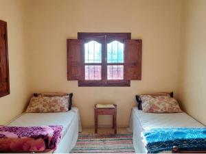 a room with two beds and a window at Guest house wakrim in Tafraout