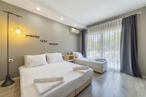 ein Schlafzimmer mit zwei Betten und einem großen Fenster in der Unterkunft Gızlıkoyhotel in Antalya
