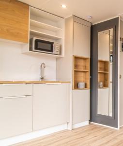 a kitchen with white cabinets and a microwave at Azor'Oasis in Calhetas +10 photos