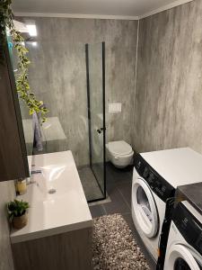 a bathroom with a washing machine and a washer at Modern apartment - Balcony, Parking, BBQ in Vossevangen