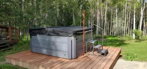 a hot tub sitting on a wooden deck with trees at Borealis Bungalow and Hot Tub in Fairbanks