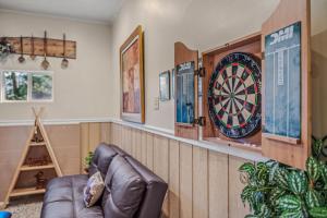 a living room with a couch and a dartboard on the wall at Khan River Cabin in Great Cacapon +146 photos