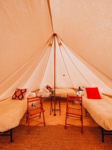 a room with two beds and two chairs in a tent at Yellowstone Glamping in Henrys Lake Airport +9 photos
