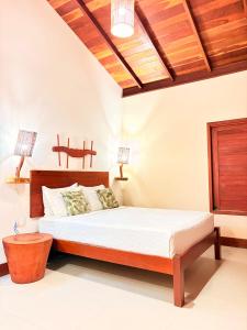 a bedroom with a bed and a wooden ceiling at POUSADA RANCHO PARAISO in Pôrto de Pedras