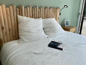 a remote control sitting on top of a bed at Alice Cottage in Cléder