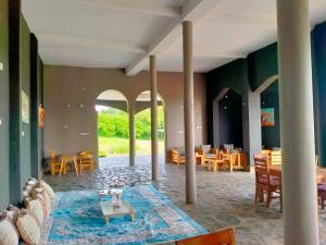 a room with tables and chairs and a room with columns at Murchison Palace in Pakwach East