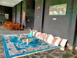 a woman sitting on a couch in a room at Murchison Palace in Pakwach East