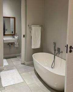a white bathroom with a tub and a sink at Luxury Property in Kingsborough