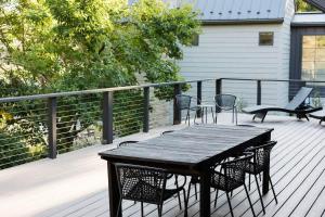 a wooden table and chairs on a deck at The Great Escape Blocks From Your Private Beach in New Buffalo