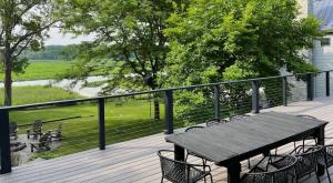 a wooden table and chairs on a deck with a view at The Great Escape Blocks From Your Private Beach in New Buffalo