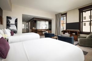 a hotel room with two beds and a living room at The Joule Dallas in Dallas