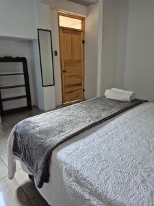 a large bed in a room with a wooden door at Home Garden in San Pedro La Laguna +3 photos
