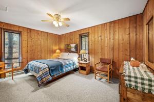 a bedroom with wooden walls and a bed and a ceiling fan at Haven Home - Deck, Grill, Hiking, Pool Access, Games, Community Playground and Tennis Courts in Berkeley Springs +60 photos
