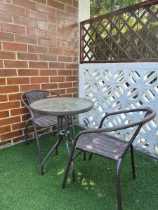 a table and two chairs sitting next to a brick wall at Home Garden in San Pedro La Laguna