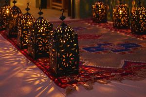 a group of lanterns are lined up on a table at Hotel Kasbah Azalay in Mhamid +126 photos