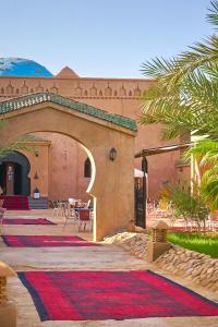 a building with a courtyard with a red carpet at Hotel Kasbah Azalay in Mhamid