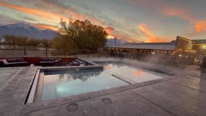 a large swimming pool with a sunset in the background at Ninepipes Lodge in Polson