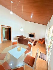 a living room with a table and a couch at Chacara Vale do Barreiro in Taubaté