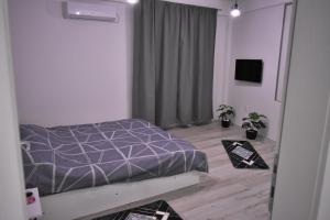 ein Schlafzimmer mit einem Bett mit einer lila Bettdecke in der Unterkunft Cavdarov in Štip