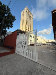 a white gate in front of a tall building at Residencial Dragão in Fortaleza