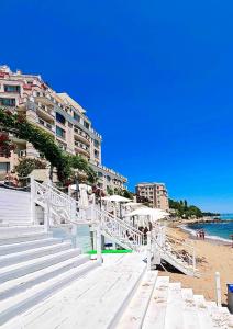 a beach with stairs leading to the ocean and buildings at La Mer Prime Time in Varna City