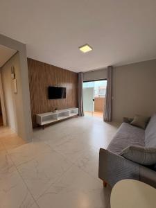 a large living room with a bed and a tv at Pousada São Gerônimo in Matinhos