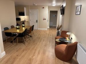 a living room with a table and chairs and a kitchen at Riverside Loft Group Accommodation in Kilkenny