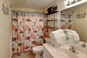 a bathroom with a toilet and a shower curtain at Summerwinds #1203 in Navarre